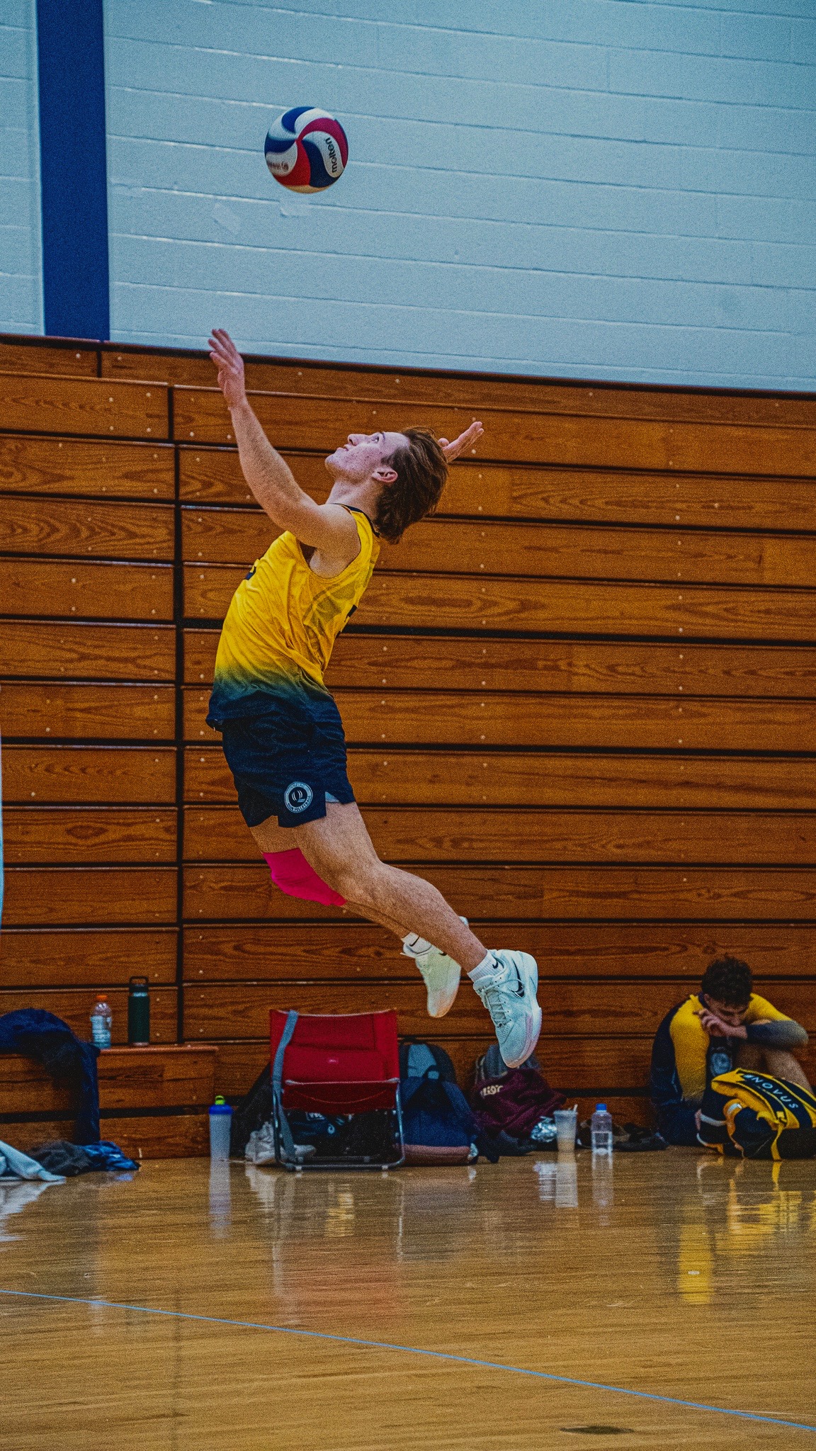 Adam serving a volleyball